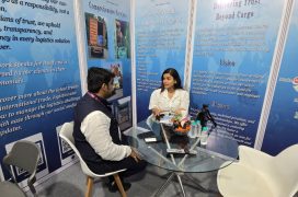 DTBC Global team member engaging with a female visitor at a logistics exhibition, discussing services and solutions
